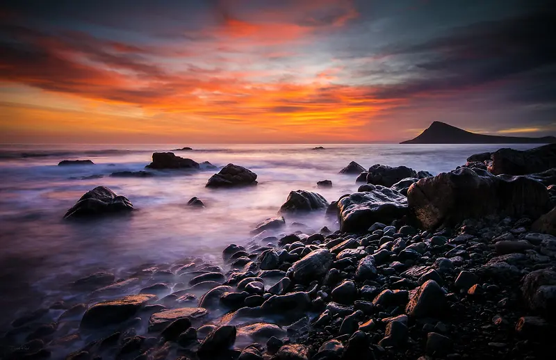 夕阳下的乱石海滩海报背景