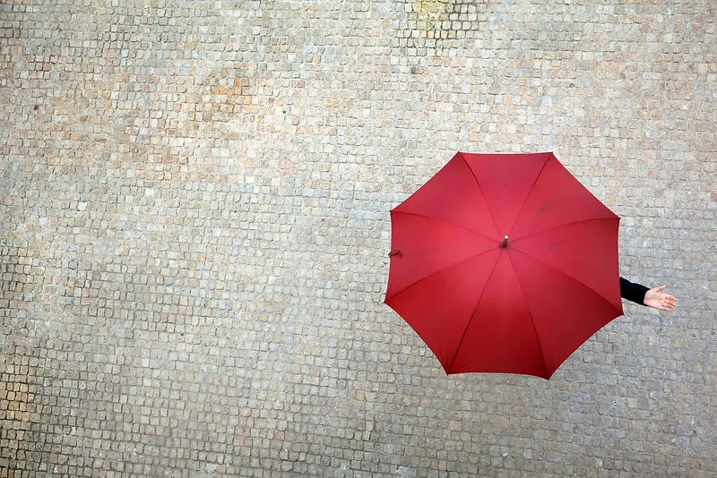 灰色砖地上的红伞