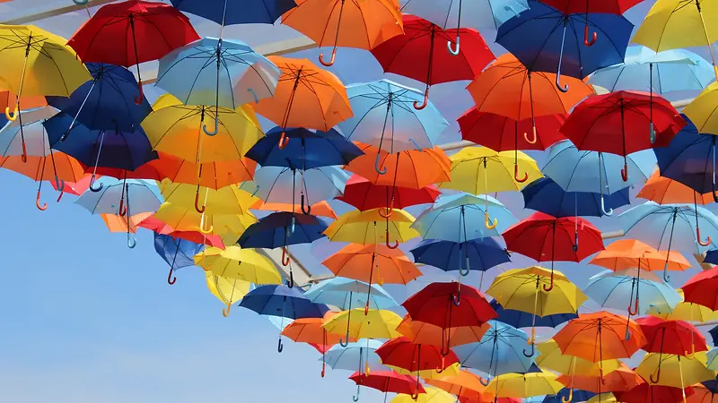 天空上的彩色雨伞海报背景
