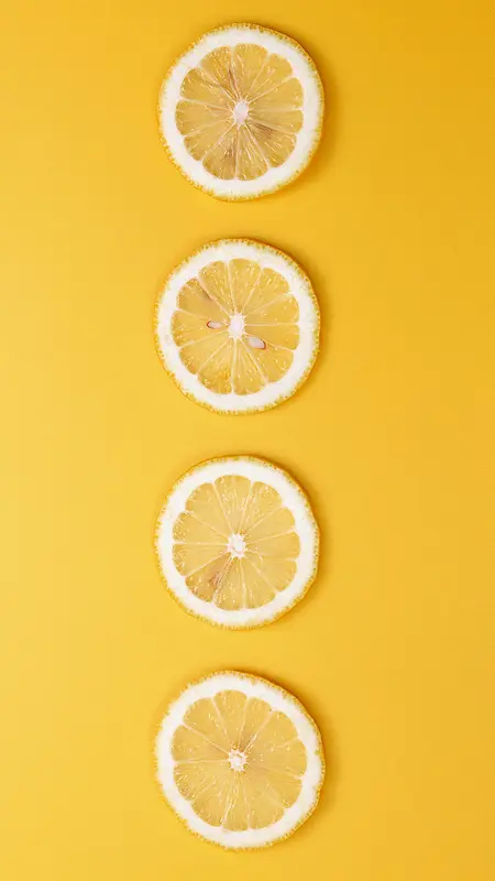 黄色背景上的四片柠檬片