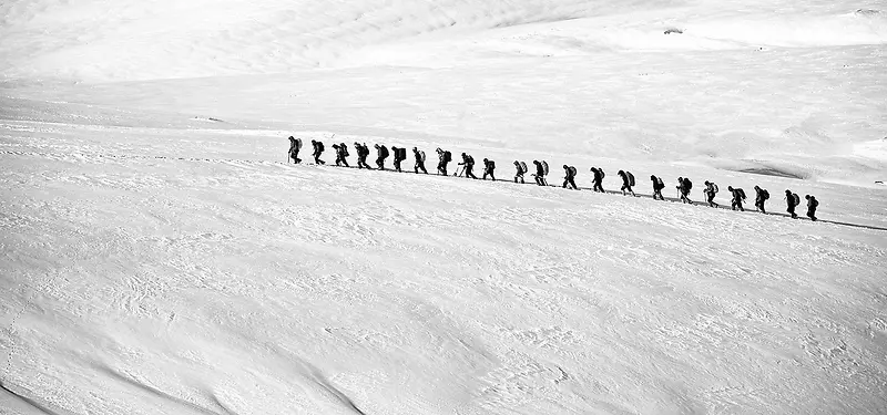 雪地上一排行走的人图片