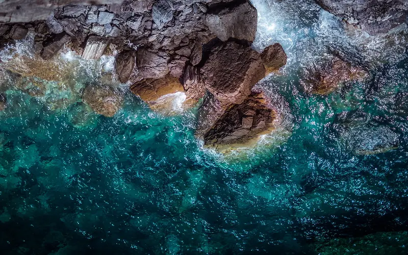 蓝色海水拍石俯瞰图背景