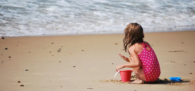 海边小女孩玩沙背景