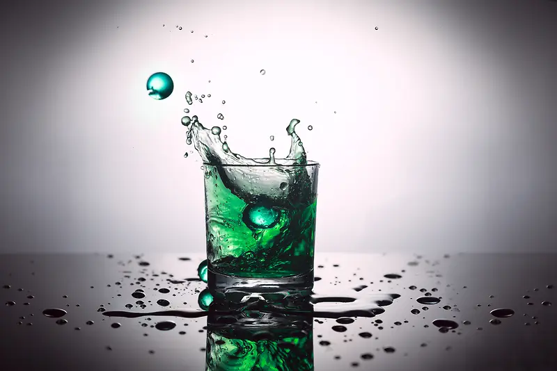 水杯里飞溅的绿色液体背景素材