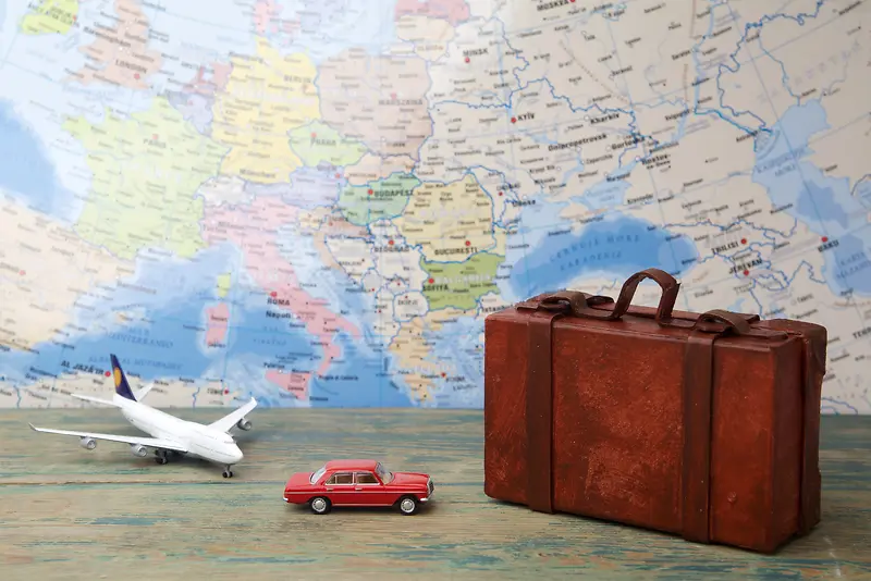 世界地图背景上的行李箱和交通工具模型背景