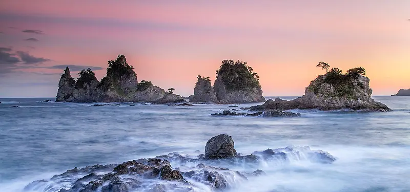 黄昏海边岩石背景图