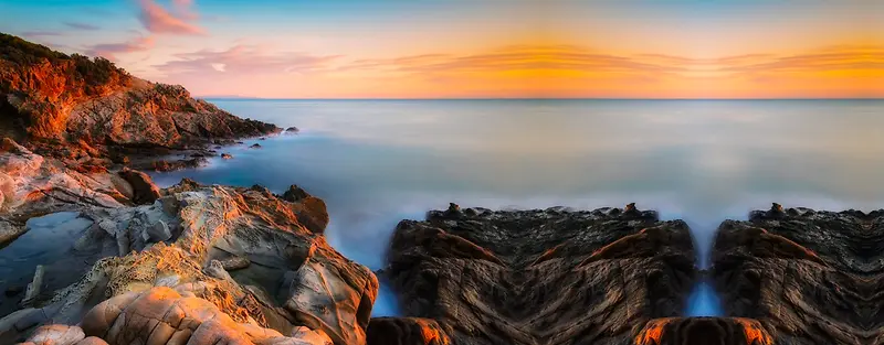 夕阳海边石头摄影海报